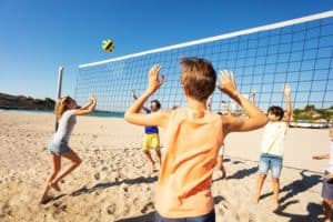 Kinder am Volleyballspielen am Strand