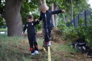 Junge blanaciert auf einer Slacklinie