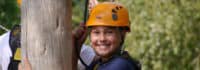 Kind lacht beim Klettern im Adventure Camp