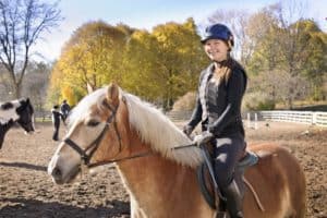 Junges Mädchen auf dem Pferd am Reiten
