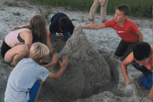 Kinder bauen eine Sandburg