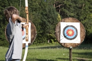 Junge schießt mit Pfeil und Bogen