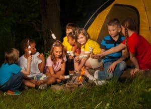 Kinder mit Marshmallow-spießen am Lagerfeuer