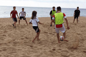 Jungs spielen Fußball am Strand