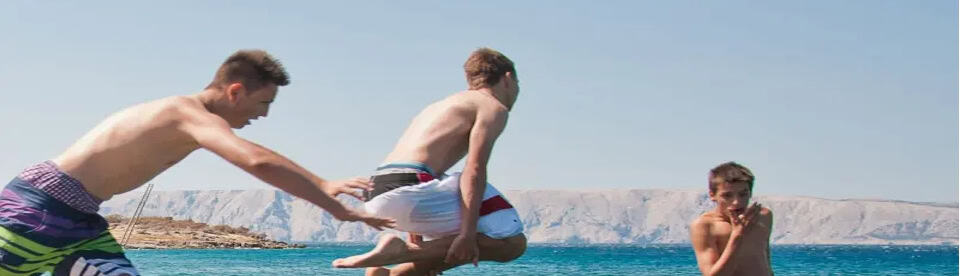 Jungs springen ins Meer