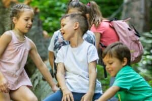 Kinder auf einem Baumstamm