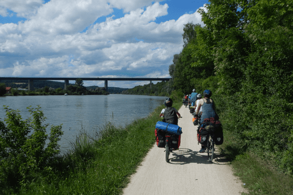 Gruppe Jugendlicher radelt entlang der Donau