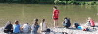 Kinder sitzen am Ufer der Donau