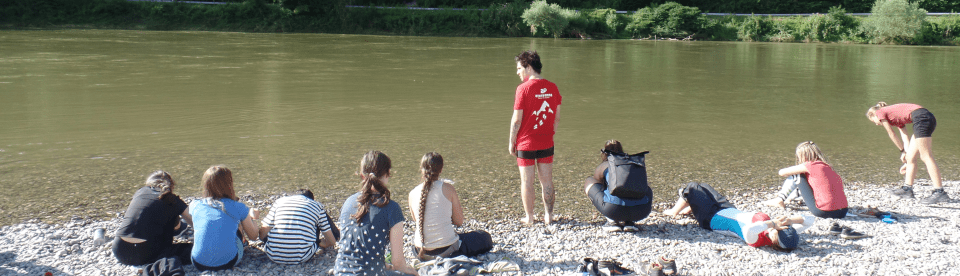 Kinder sitzen am Ufer der Donau