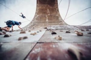 Teilnehmer klettern an der Kletterwand im Klettercamp im Bayerischen Wald
