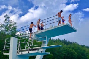 Eine Gruppe von Kindern steht auf dem Sprungturm im Schwimmcamp