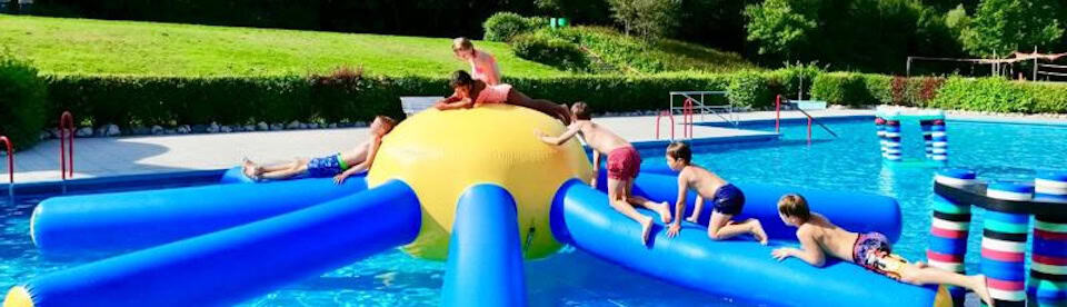Spaß im Freibad auf einer Hüpfburg im Wasser