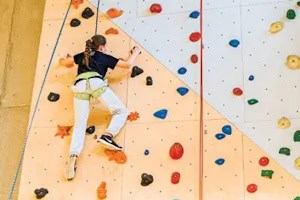 Mädchen an Kletterwand im Ninja Warrior Camp