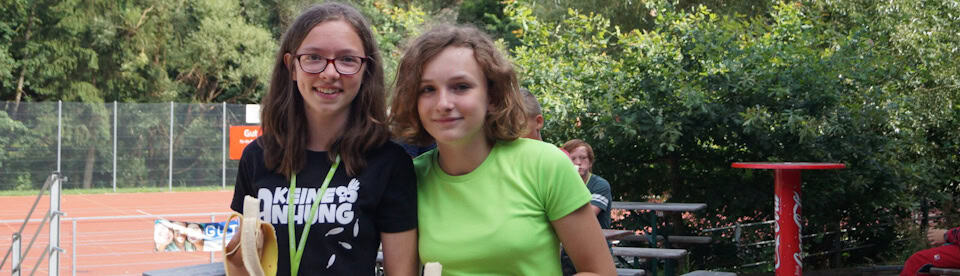 Mädchen stehen vorm Tennisplatz