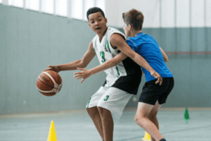 Zwei Kinder die Basketball in einer Halle spielen im Multisportcamp Werdau