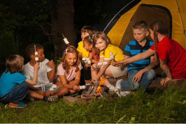 Kinder bei Lagerfeuer und Stockbrot