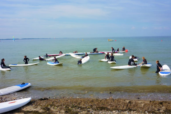 Viele Kinder sitzen auf Surfboards im Wasser