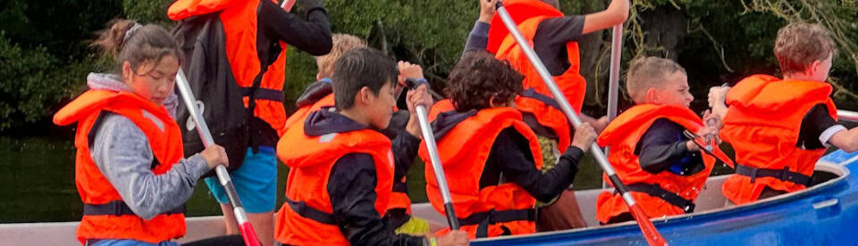 Kinder fahren Kanu