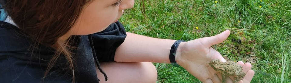 Mädchen hält Frosch in der Hand
