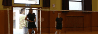 Trainerin und Junge hinter Bdmintonnetz