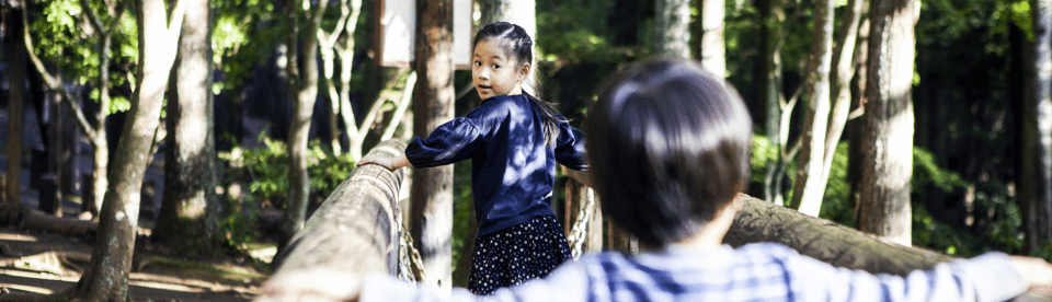 Kinder beim Klettern im Wald