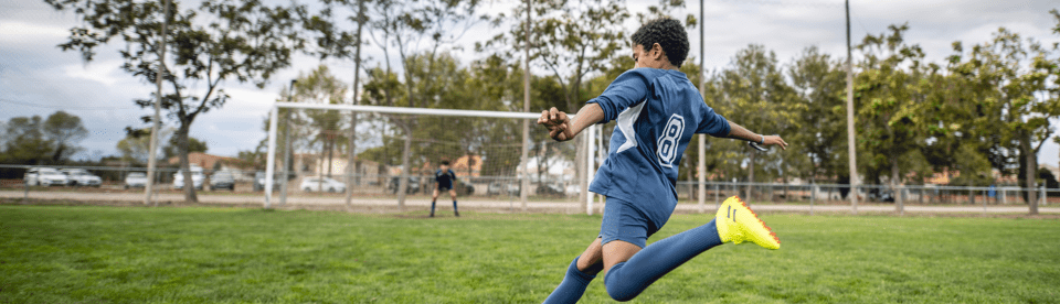 Junge zielt beim Fußball aufs Tor