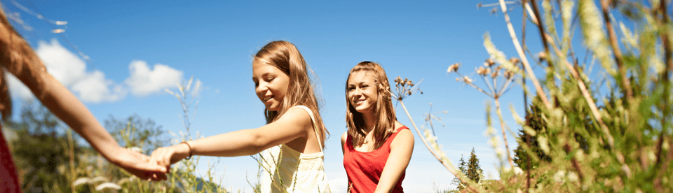Kinder laufen durch hohes Gras