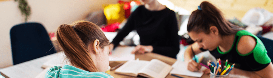 Kinder sitzen am Tisch und lernen
