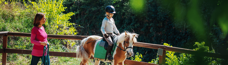 Ein Mädchen reitet auf einem Pony