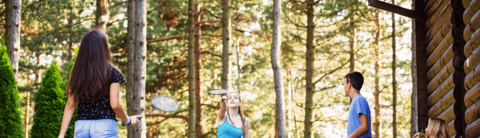 Kinder spielen Badminton in der Natur