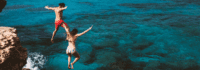 Jugendliche springen von Fels ins Meer