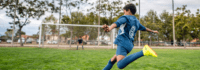 Junge spielt Fußball und zielt aufs Tor