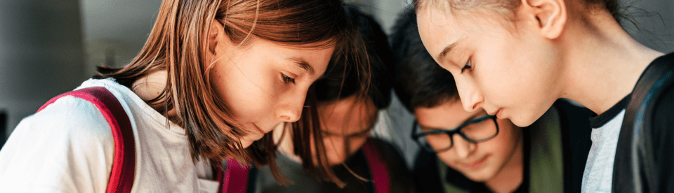 Kinder schauen gemeinsam auf eine Karte