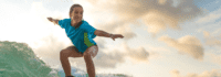 Mädchen steht auf Surfboard
