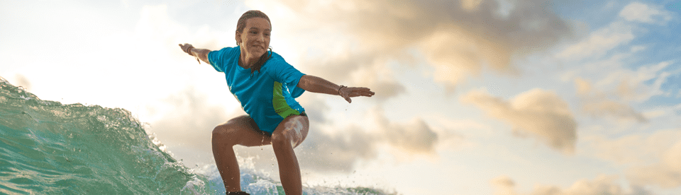 Mädchen steht auf Surfboard