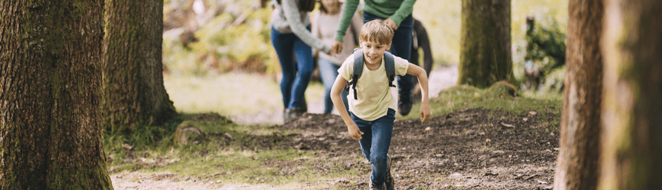 Junge läuft Hang im Wald rauf