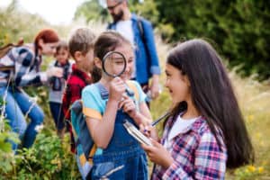 Mädchen schaut durch Lupe, Englischcamp Dresden
