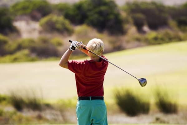 Junge auf dem Golfplatz im Tagescamp