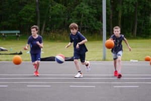 Drei Jungs dribbeln mit Basketbällen