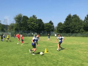 Junge dribbelt um Hütchen