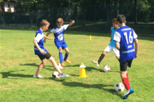 Jungs mit Fußball in den Sommercamps in Bayern