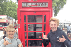 Zwei Jungs vor einer roten Telefonzelle