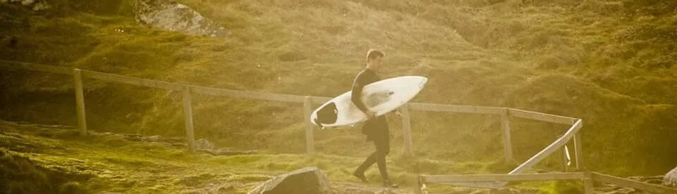 Surfer in Cornwell auf dem Weg zum Strand
