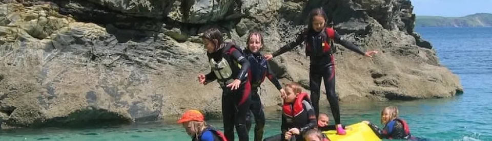 Kinder im Wasser in einer Bucht in Cornwall