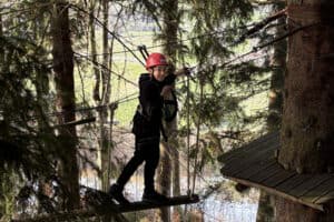 Kind klettert im Hochseilgarten im Feriencamp Allgäu