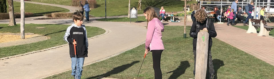 Ein Mädchen spielt Minigolf