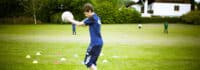 Junge trainiert mit Ball im Multisportcamp