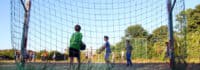 Kinder spielen Fußball auf einer Wiese