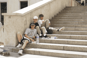 Jungs sitzen auf einer Treppe im Skatecamp Paris