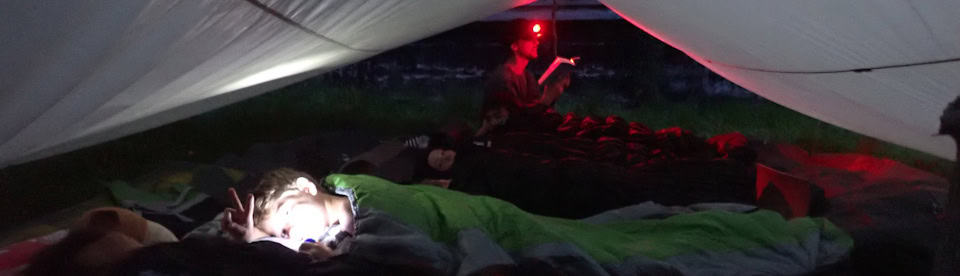 Kinder schlafen draußen unter einer Plane